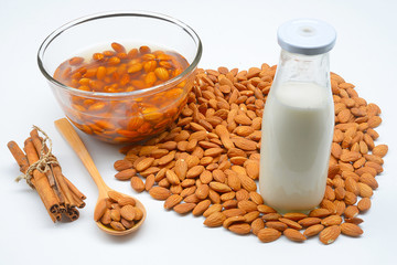 Raw almonds soaking in a white bowl of water