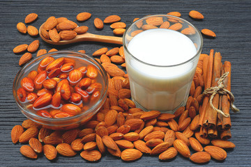 Raw almonds soaking in a white bowl of water