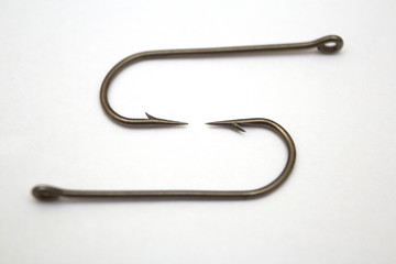 Two fishing hooks on a white paper background