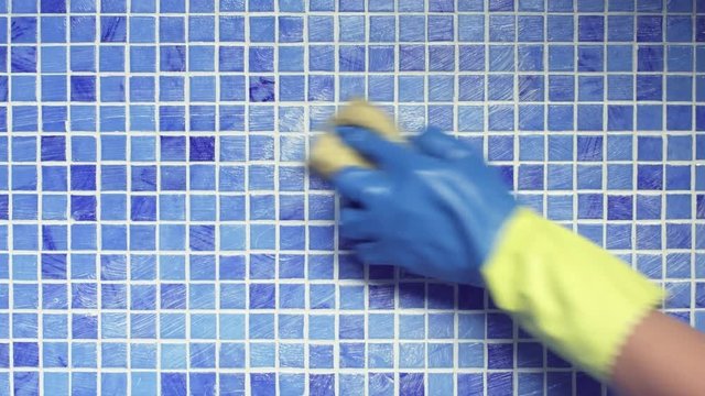Cleaning swimming pool tile with sponge