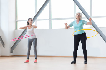 Fototapeta na wymiar Sporty active women rotating hula hoops