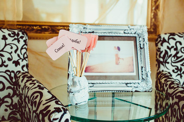 Sticks with pink cards stand before the newlyweds' picture in si