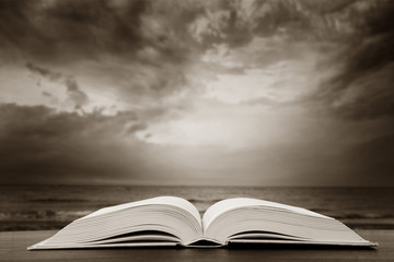 Open book over the landscape background