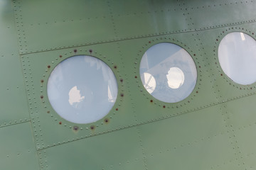 Window in old airplane, aluminum background detail of a military aircraft