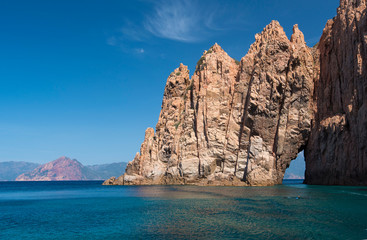 Sculpted red rock with a gap in the Gulf of Porto