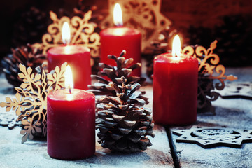 Burning red candles and pine cones with snowflakes, Christmas or