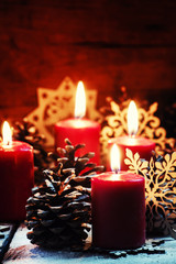 Burning red candles and pine cones with snowflakes, Christmas or