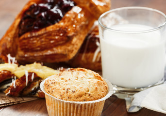 pastries, buns, custard cake, a glass of milk on the table. Close-up