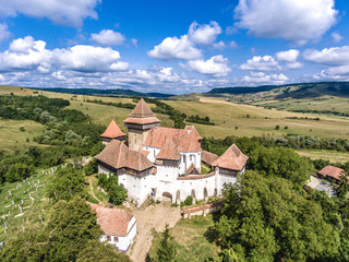 Viscri fortified Chruch in the middle of Transylvania, Romania. Aerial view from drone. Important tourist attraction. UNESCO heritage site.