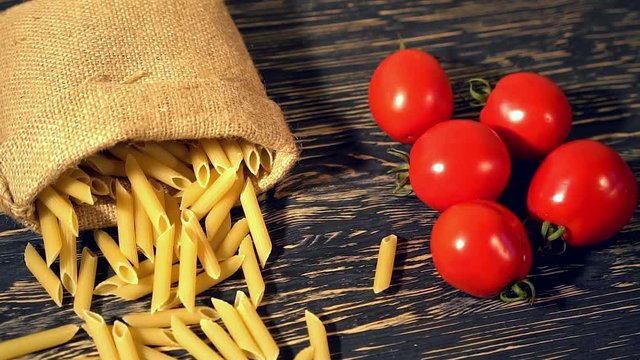 Tomato and pasta on wooden background