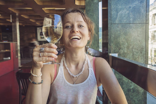 Woman with glass of wine doing heers