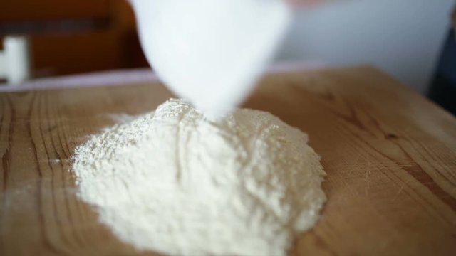 Uomo mezza et&agrave; che sta facendo la pasta fatta in casa su un tagliere di legno.