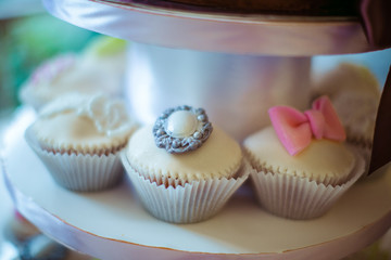White cupcakes decorated with glaze brooch