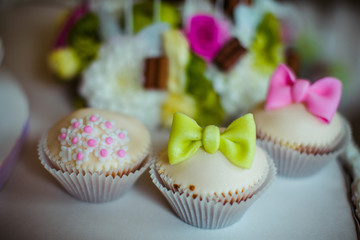 White cupcakes decorated with glaze bows and flowers
