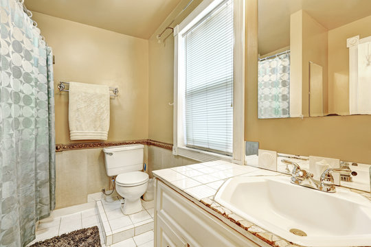 Old style bathroom interior with white tile floor