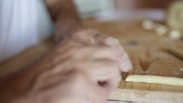 Preparazione delle orecchiette fatte in casa su un tagliere di legno. 