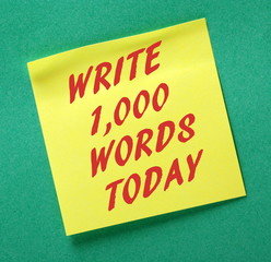 The words Write one thousand Words Today on a yellow sticky note as motivation for aspiring authors to start a book