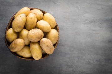 New potato on the bowl, gray background.