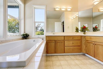 Fototapeta na wymiar Luxury bathroom interior with wooden cabinets and white bathtub
