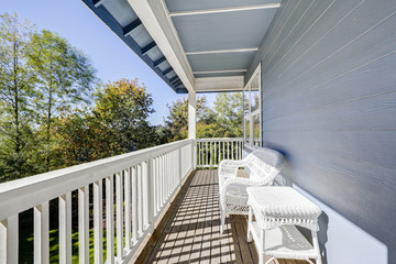 Sunny walkout deck with white wicker furniture