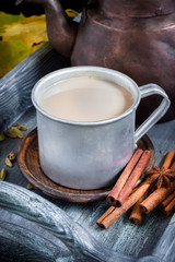 Hot beverage in big metal mug and spices.