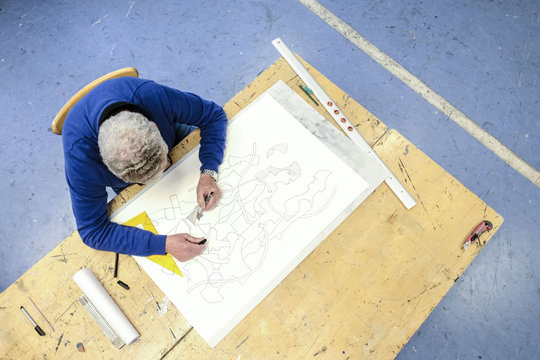 Top view of artist drawing in his studio