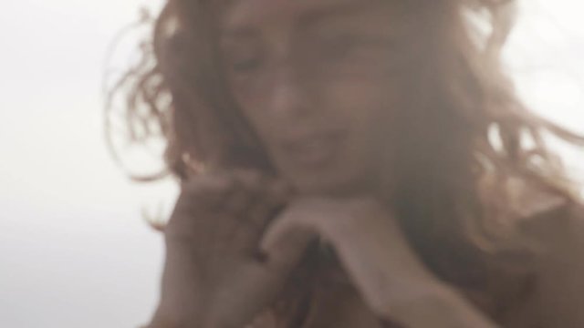 Sexy young woman with pink curly hair sitting on the parapet and posing