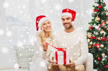 happy couple at home with christmas gift box