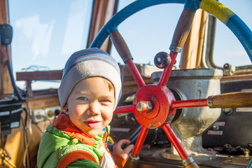 the boy is at the helm on the ship © vitec40