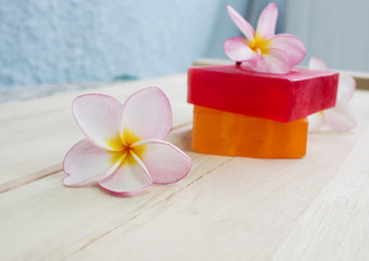 Obraz na płótnie Canvas Soap and frangipani flower on wooden floor massage and spa concept background