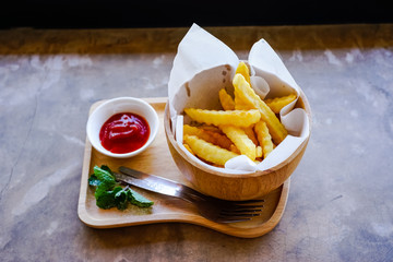 French fries with ketchup on wood tray