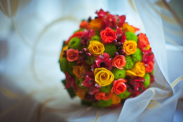 A blurred picture of bright green and orange wedding bouquet lyi