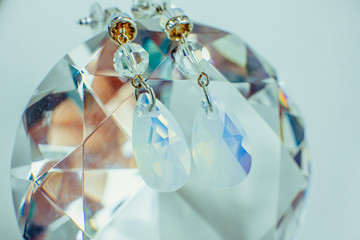Crystal earrings lie over a crystal ball