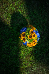 Yellow and blue wedding bouquet lies in the ray of light on the