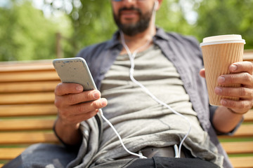 Fototapeta premium man with earphones and smartphone drinking coffee