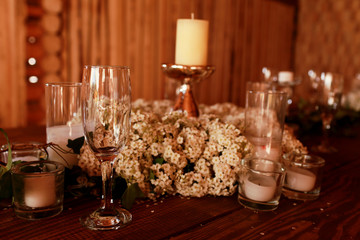 Candles in glasses stand around the white wreath
