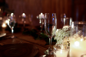 Empty glassware surround white wreath on the dinner table