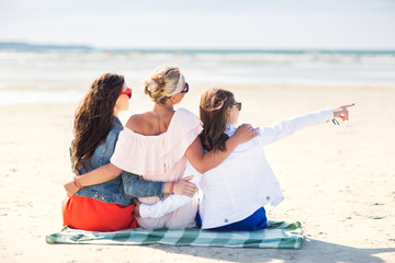 group of young women hugging on beach