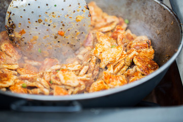 close up of meat in wok pan at street market