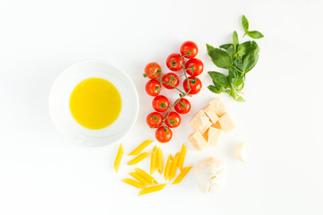 Italian food  close up with red tomatoes, pasta, basil leafs, cheese, olive oil and garlic, isolated on white background - Flat lay