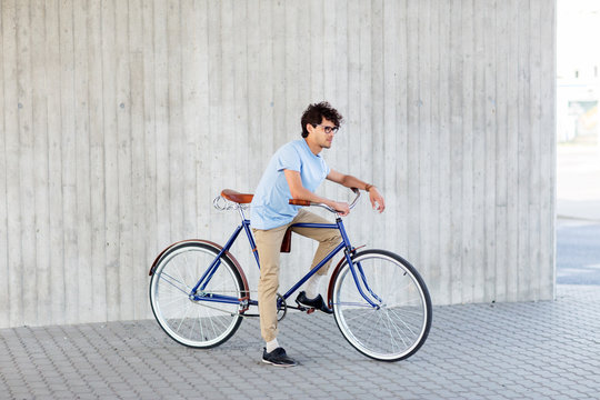 young hipster man riding fixed gear bike