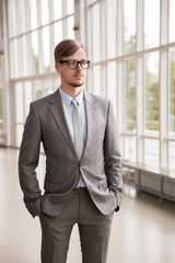 young businessman in suit and glasses at office