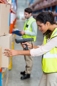 Female warehouse worker scanning box