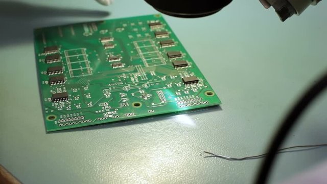 Worker soldering components to printed circuit board
