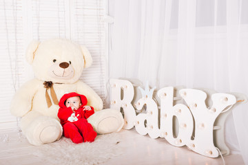 Baby boy with letters of the word baby on the floor