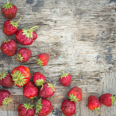 Background with strawberry on a textured wooden surface with cop