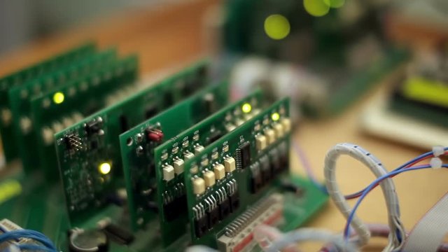 Blinking leds on green circuit board, industrial equipment test stand assembly