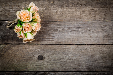 Bouquet of little beige roses on wooden background