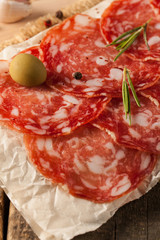 Chorizo sausage and salami, thin cut. spanish salami on the wood background with spices, paprika, pepper. Spicy food. Chili.