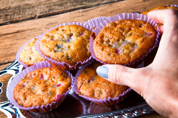 Hand of a girl taking a muffin. Top view. Copyspace